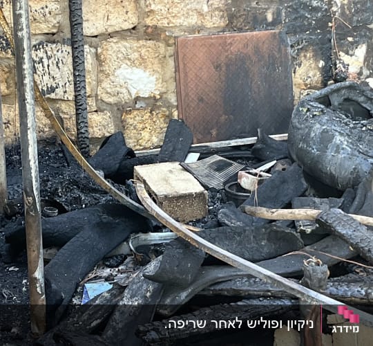 הריסות שריפה עם קירות אבן וחפצים שרופים